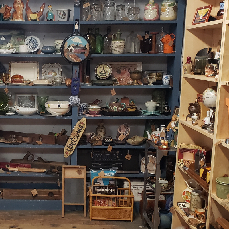 Shelves of antiques, glassware, and collectibles at Liberty Tool Company in Maine